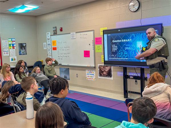 police officer talking to class of students